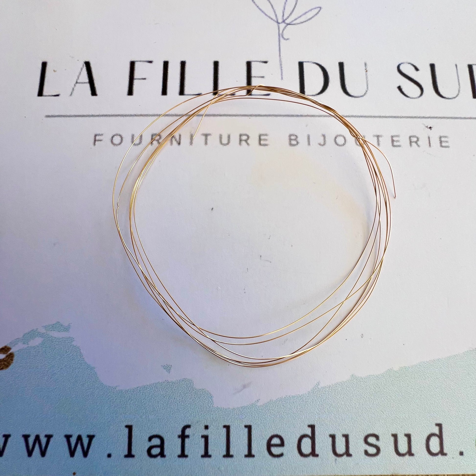 Fil rond en or rose 18 carats massif de 0,20mm présenté sur la carte de l'atelier La Fille du Sud.