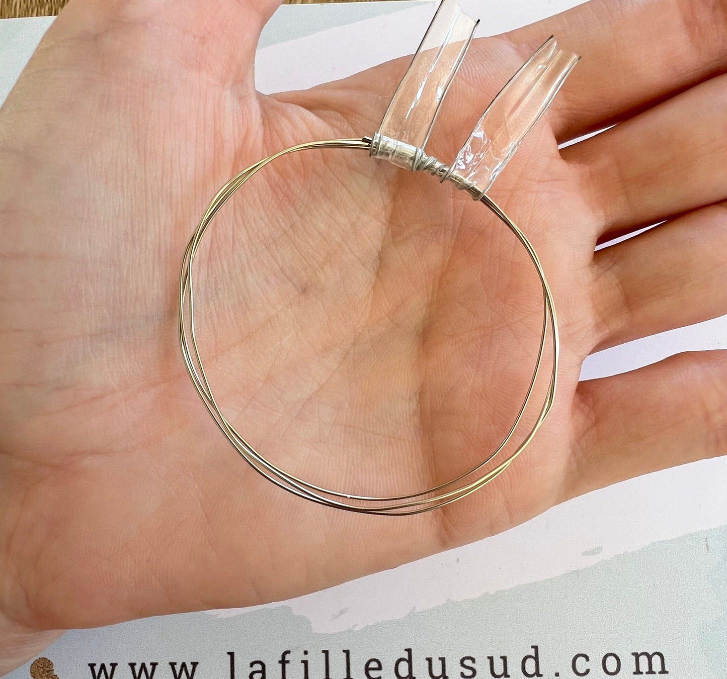 Aperçu de la finesse d'un fil d'or blanc 18 carats de 0,50 mm dans la paume d'une main.