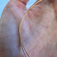 Aperçu de la finesse et de la souplesse d'un fil d'or rose 18k de 0,50 mm dans la main