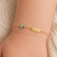 Rendu d'une gourmette bébé coccinelle bleue turquoise en or 18 carats sur la peau, un bijou de naissance original et coloré.