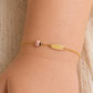 Gourmette pour bébé fille avec motif coccinelle rose en résine et or jaune 18 carats, vue du bijou porté.