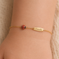 Exemple de personnalisation avec gravure de prénom sur la plaque d'une gourmette bébé coccinelle en or 18 carats.