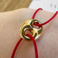 Bracelet cordon rouge porte-bonheur avec un graine de café en or 18 carats.
