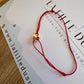 Bracelet cordon rouge porte-bonheur avec un graine de café en or 18 carats.