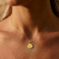 Gros plan sur une femme portant la médaille de Saint Benoît en or jaune 18 carats, un puissant symbole de protection de 16 mm de diamètre.