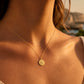 Gros plan sur une personne portant la médaille Saint Christophe en or jaune 18 carats massif, finition mate et bord perdu, diamètre 18 mm.