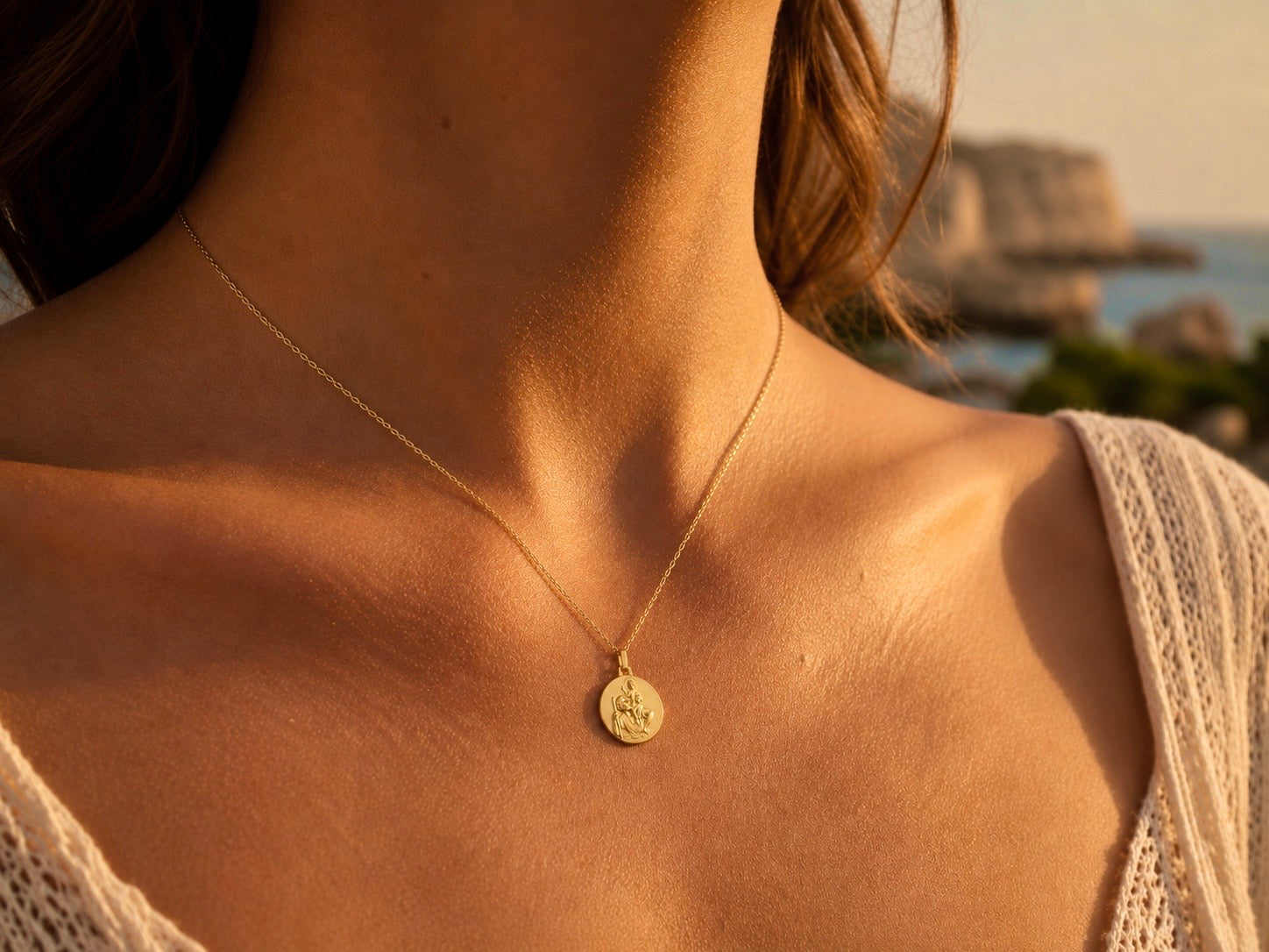 Gros plan sur une personne portant la médaille Saint Christophe en or jaune 18 carats massif, finition mate et bord perdu, diamètre 18 mm.