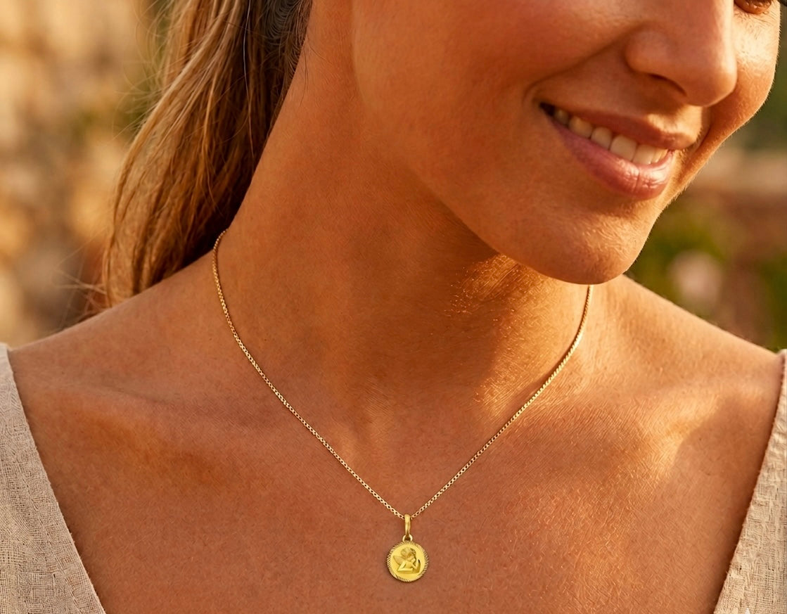 Gros plan sur une femme portant la médaille Ange Rêveur en or jaune 18 carats, un pendentif symbolique et protecteur de l'atelier La Fille du Sud.
