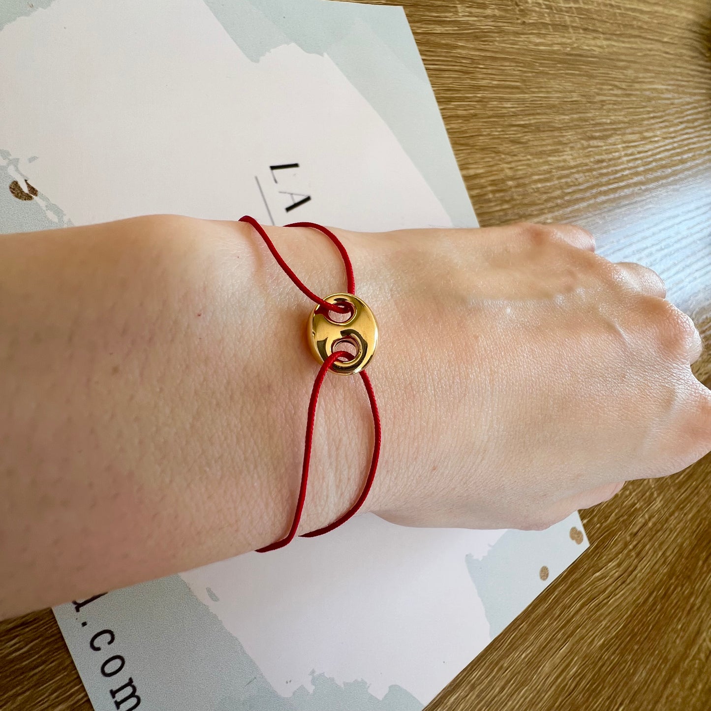 Bracelet cordon rouge porte-bonheur avec un graine de café en or 18 carats.