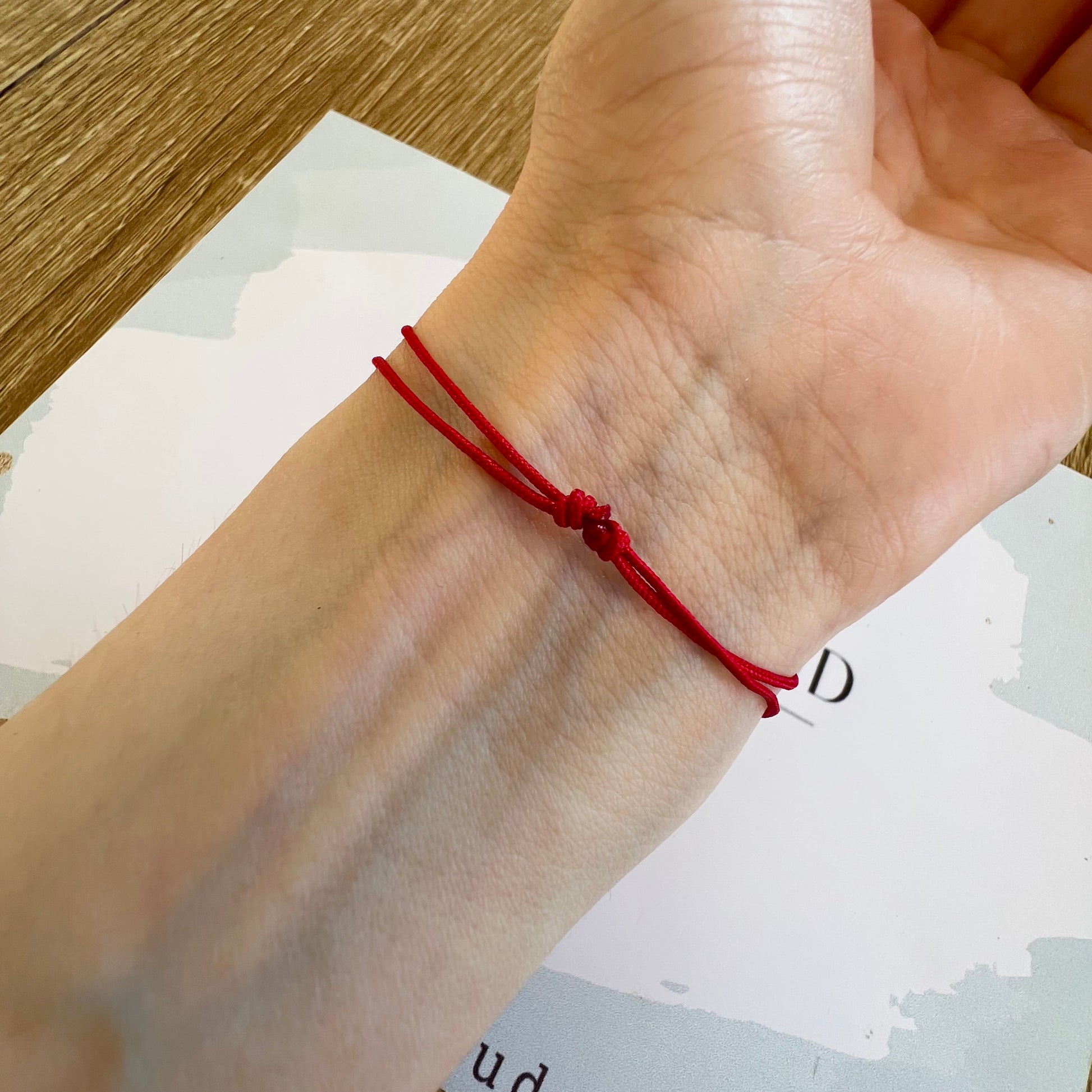 Bracelet cordon rouge porte-bonheur avec un graine de café en or 18 carats.