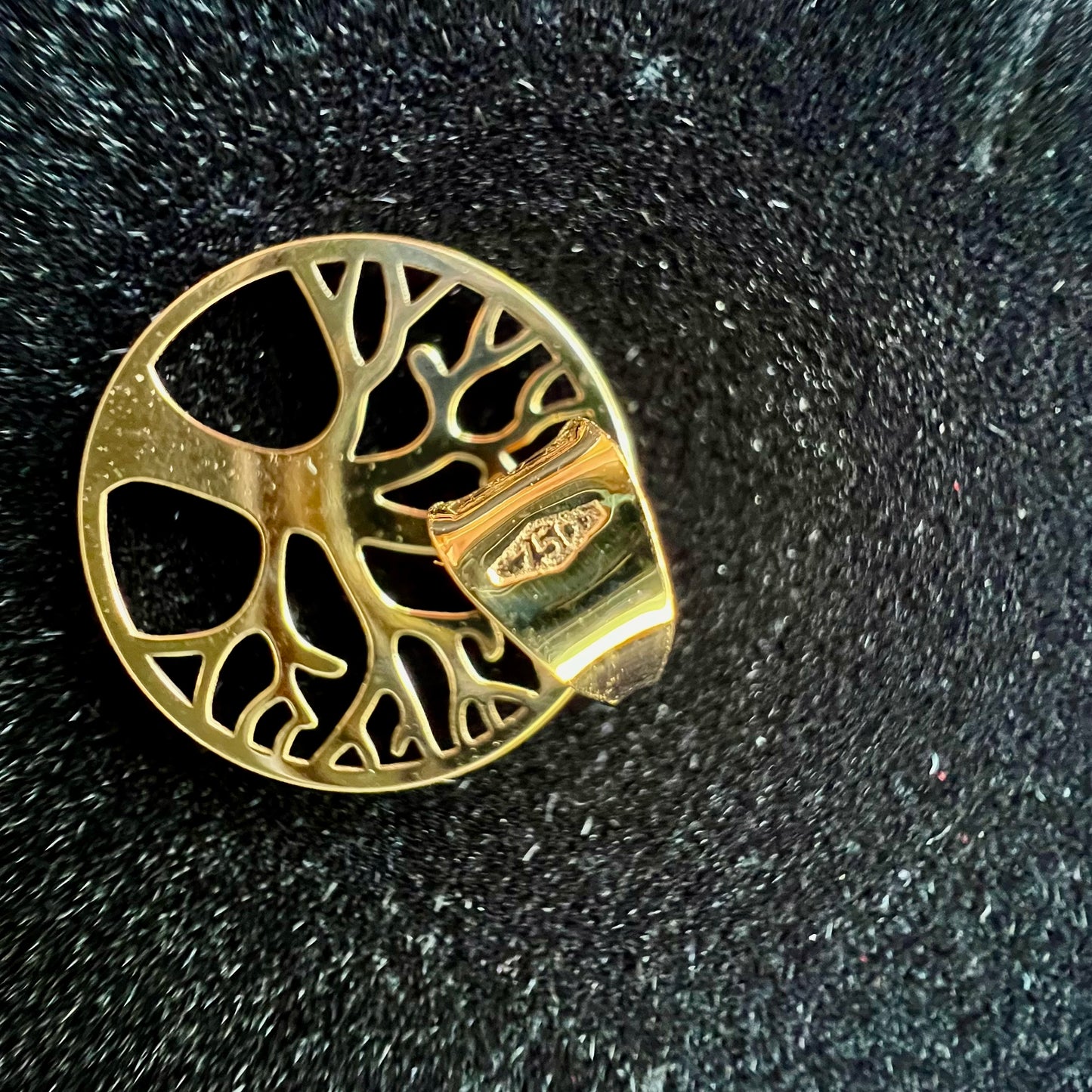 Gros plan de l'arrière ajouré du pendentif arbre de vie en or jaune 18 carats massif, montrant le poinçon officiel gravé sur la bélière.