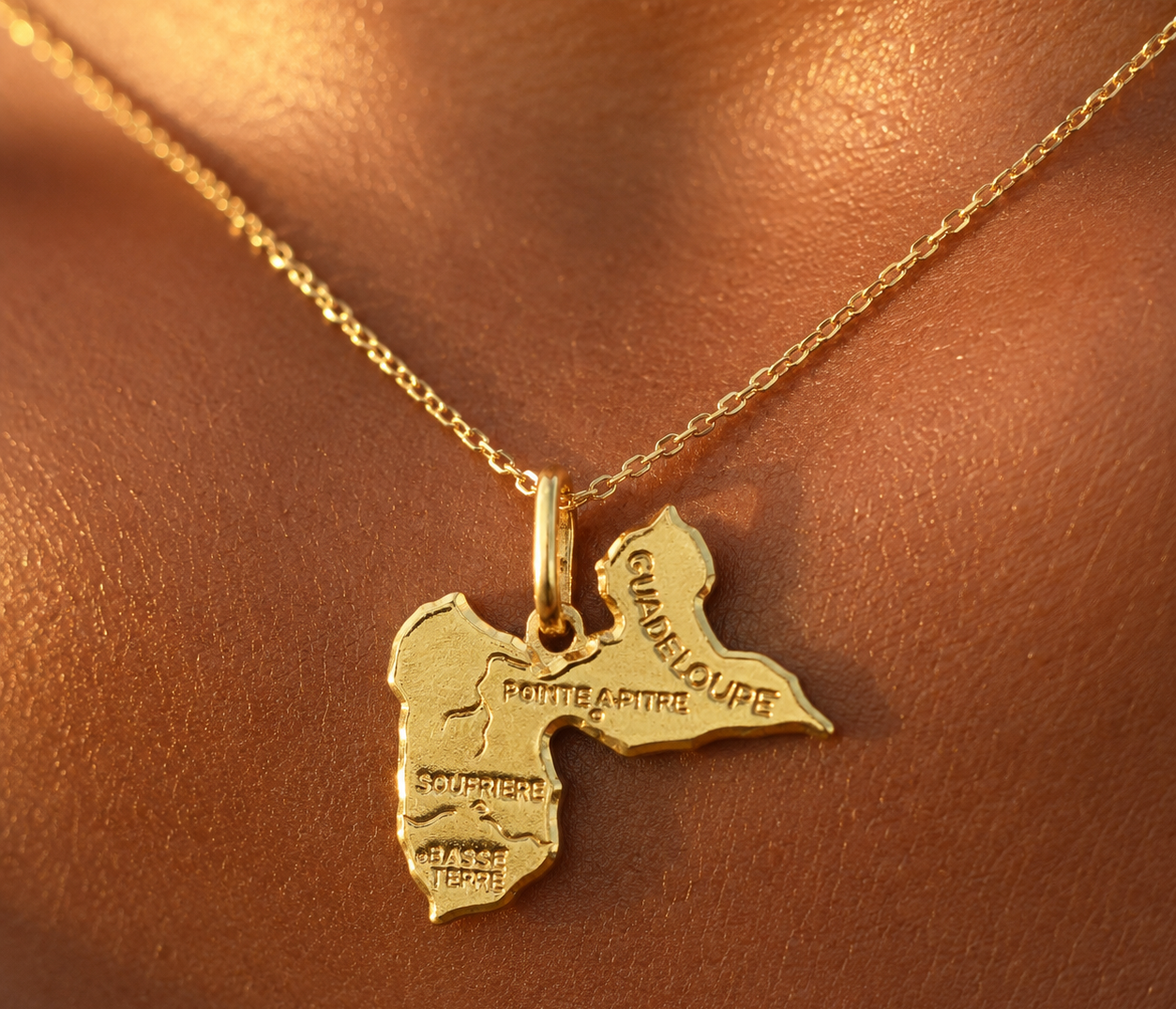 Pendentif carte de la Guadeloupe en or 18 carats porté sur une chaîne en or jaune au soleil.