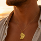 Collier carte de la Guyane en or jaune 18 carats massif porté par un homme au soleil.