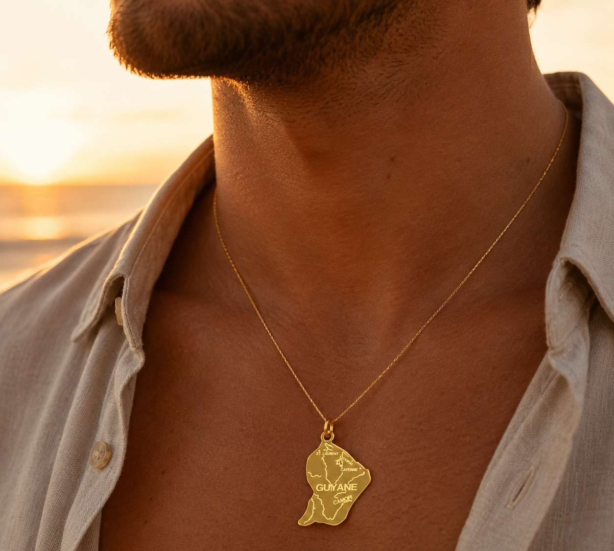 Collier carte de la Guyane en or jaune 18 carats massif porté par un homme au soleil.
