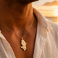 Pendentif carte de la Martinique en or jaune 18 carats massif porté par un homme sur une chaine en or.