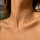 Gros plan sur le décolleté d'une femme portant un pendentif en forme de clé en or jaune 18 carats serti de diamants naturels.
