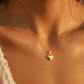 Gros plan sur le décolleté d'une femme portant un petit pendentif cœur bombé en or jaune 18 carats, bijou de peau minimaliste et brillant.
