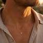 Gros plan sur le cou d'un homme portant le pendentif colibri en or jaune 18 carats, un bijou animal totem au design fin et élégant.