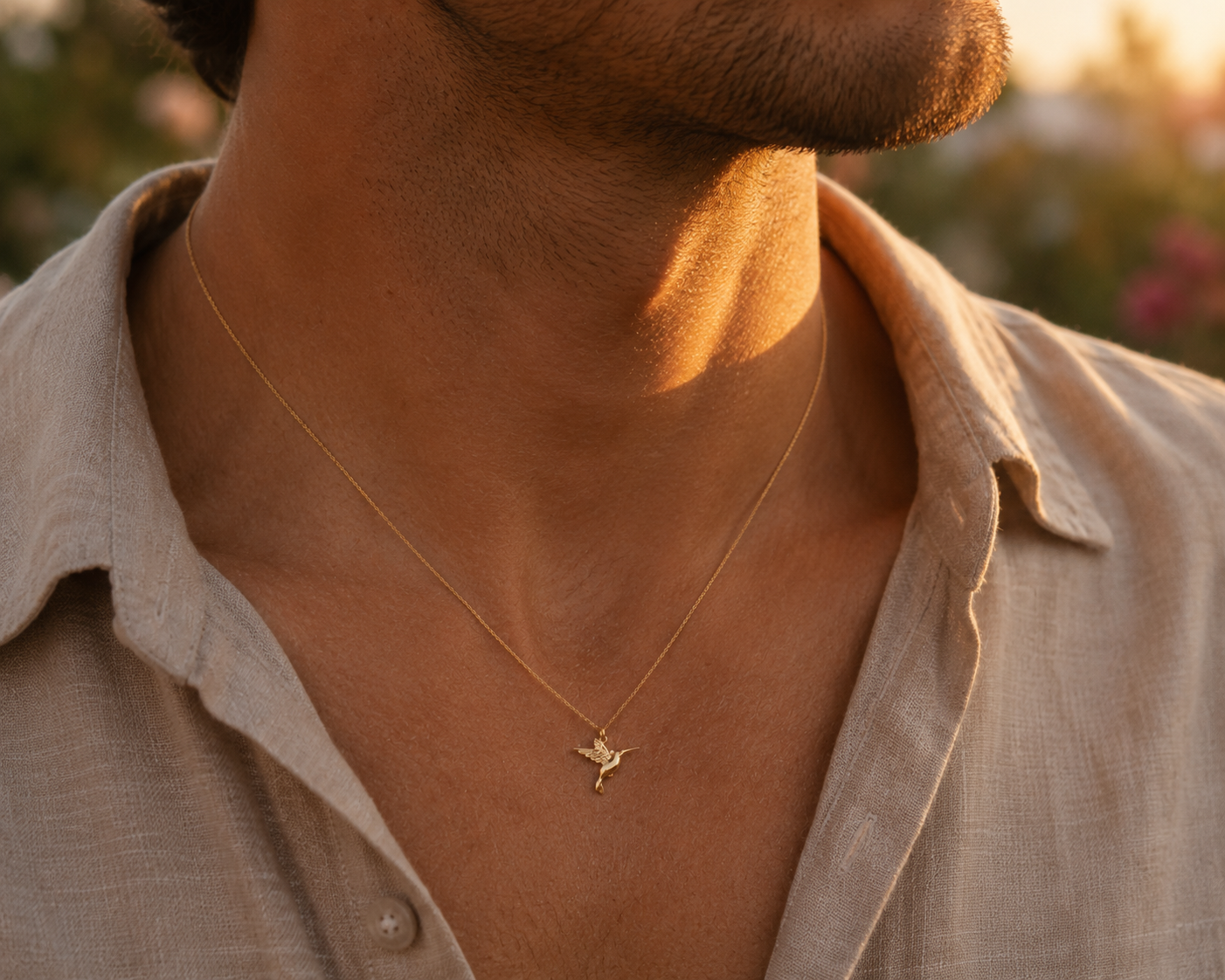 Gros plan sur le cou d'un homme portant le pendentif colibri en or jaune 18 carats, un bijou animal totem au design fin et élégant.