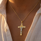 Pendentif croix de protection Saint Benoît en or jaune et blanc 18 carats porté au cou sur une chaîne fine.
