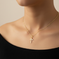 Collier avec un pendentif croix en or et diamant, porté par une femme