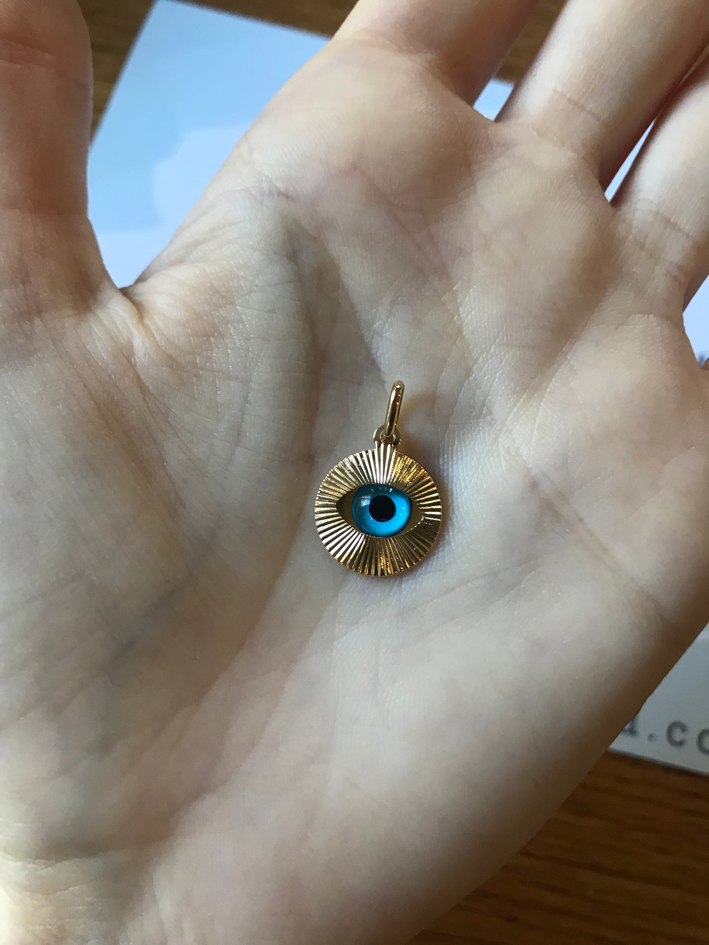 Petite taille discrète de 14mm pour ce pendentif oeil protecteur posé dans la main, bijou oeil bleu or 18k.