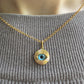  Femme portant un collier avec oeil bleu protecteur en or 18 carats sur une chaîne fine, style ras-de-cou élégant.