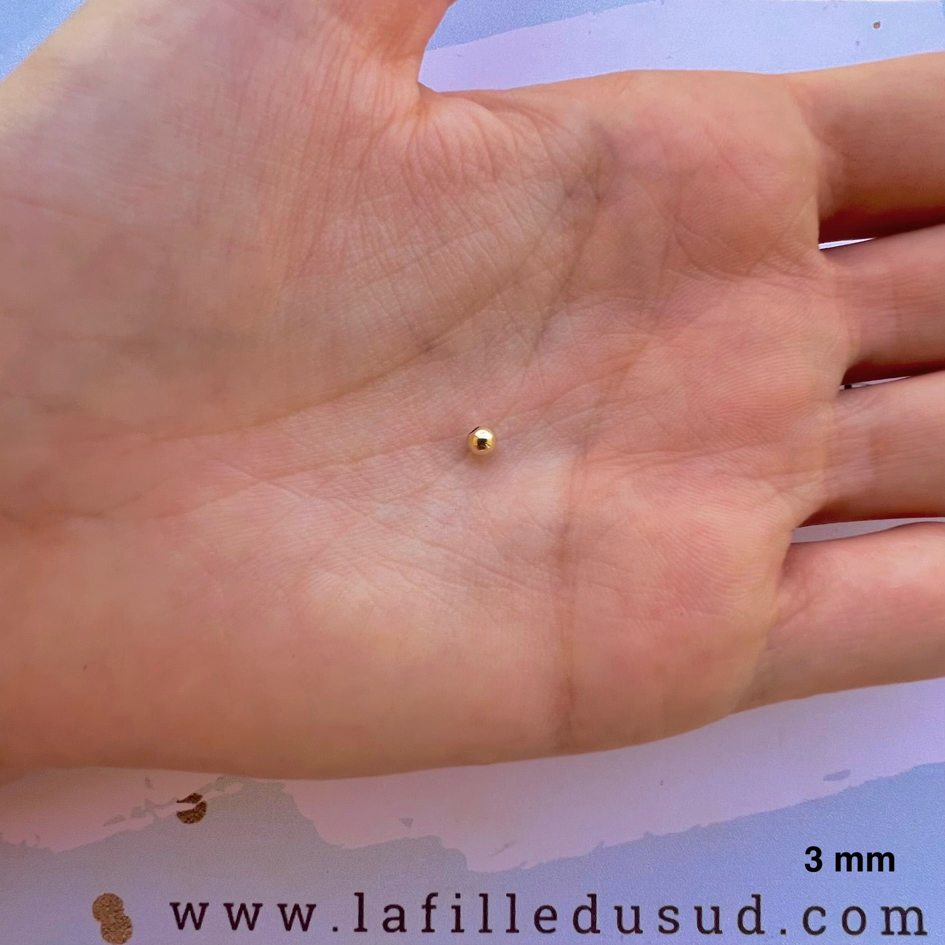 Aperçu de la taille réelle de la perle en or jaune 9 carats de 3 mm dans la paume d'une main.
