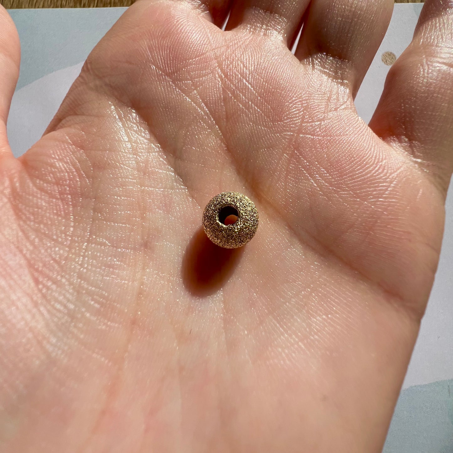 Perle d'or granitée à 2 trous en or jaune 18 carats pour la création de bracelets.