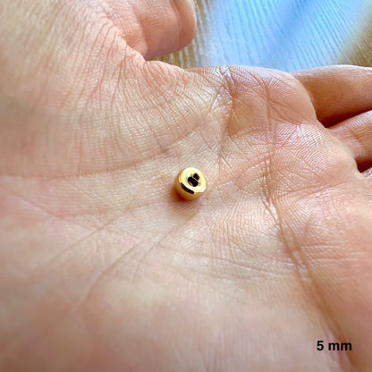 Aperçu de la taille réelle d'une perle intercalaire rondelle de 5 mm dans la paume d'une main