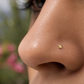 Gros plan sur la narine d'une femme portant un piercing nez étoile en or jaune 18 carats, un bijou de nez discret et élégant de l'atelier La Fille du Sud.