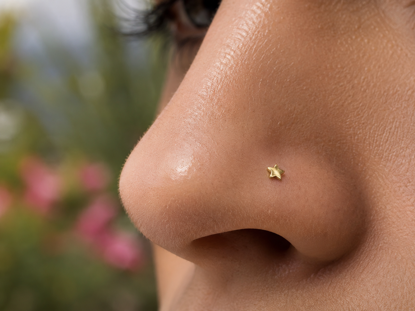 Gros plan sur la narine d'une femme portant un piercing nez étoile en or jaune 18 carats, un bijou de nez discret et élégant de l'atelier La Fille du Sud.