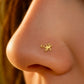 Piercing de nez salamandre en or jaune 18 carats porté discrètement sur le flanc de la narine au soleil.