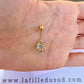 Taille réelle du piercing de nombril fleur en or jaune 18 carats dans la paume d'une main.