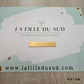 Plaque en or jaune 18 carats de 5 cm par 1 cm présentée sur la carte de l'atelier La Fille du Sud.