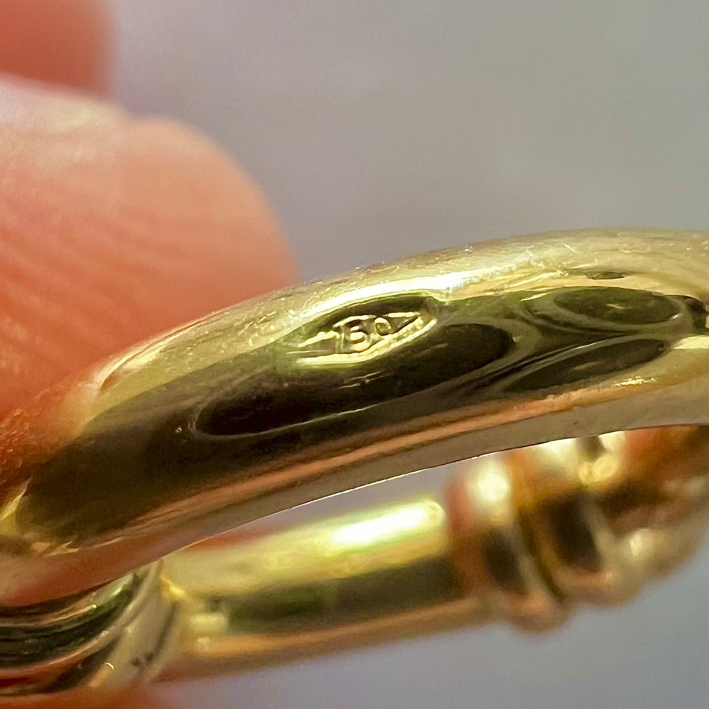Zoom sur le poinçon d'état 750 garantissant l'authenticité de l'or 18 carats sur le fermoir bouée ovale.