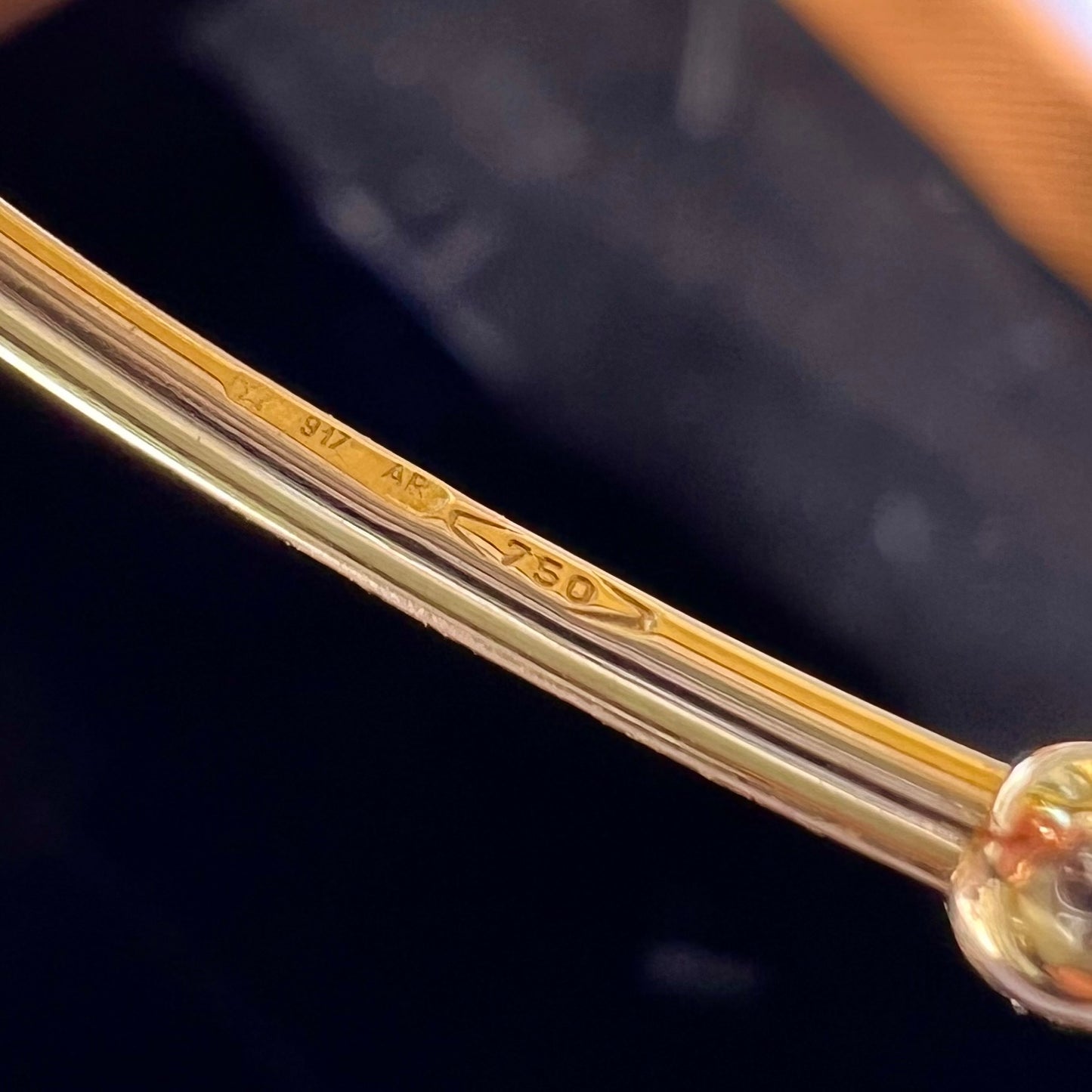 Zoom sur le poinçon de garantie officiel 750 certifiant l'or 18 carats massif du bracelet jonc