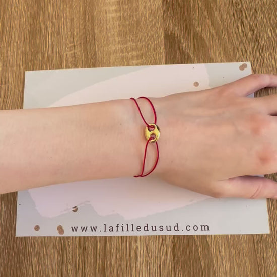 Bracelet cordon rouge porte-bonheur avec un graine de café en or 18 carats.