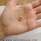 Démonstration du système de charnière invisible sur un fermoir rond en or rouge 18k.
