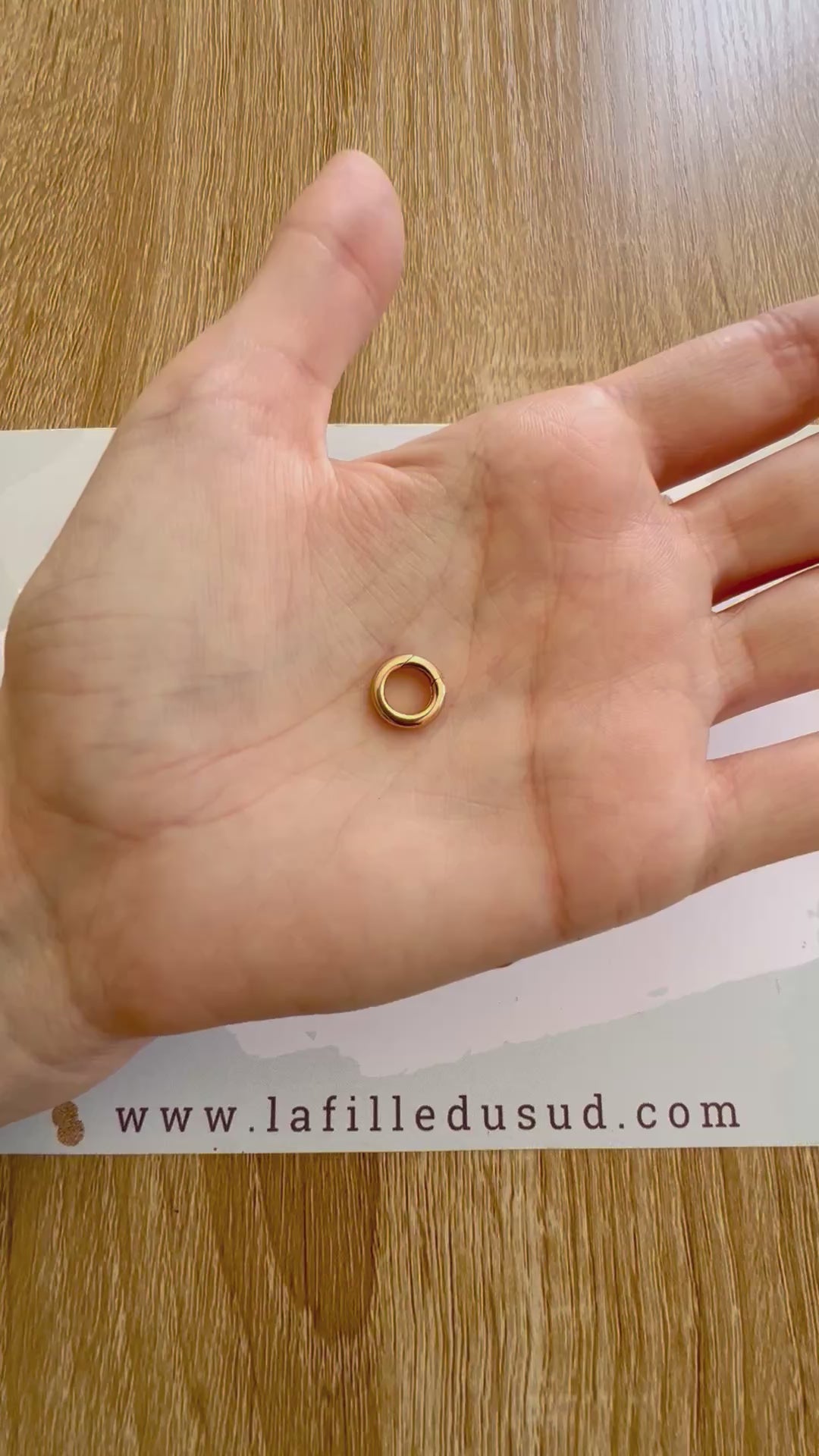 Démonstration du système de charnière invisible sur un fermoir rond en or rouge 18k.