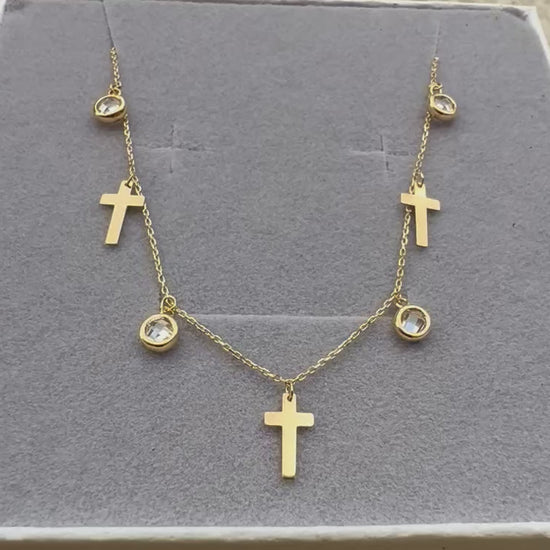 Vidéo de la chaîne de cheville en or jaune 18 carats, ornée de pampilles en forme de croix et d'oxydes de zirconium scintillants, délicatement présentée dans son écrin.