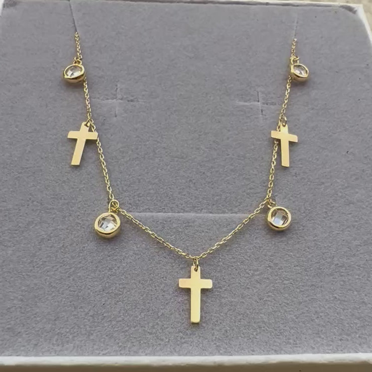 Vidéo de la chaîne de cheville en or jaune 18 carats, ornée de pampilles en forme de croix et d'oxydes de zirconium scintillants, délicatement présentée dans son écrin.
