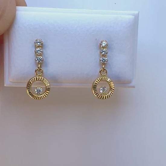 Boucles d'oreilles pendantes en or jaune 18 carats, design cercle évidé serti d'oxydes de zirconium qui scintillent au soleil