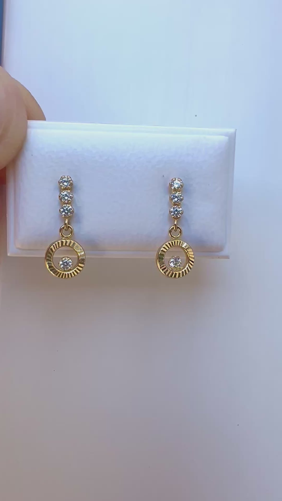 Boucles d'oreilles pendantes en or jaune 18 carats, design cercle évidé serti d'oxydes de zirconium qui scintillent au soleil