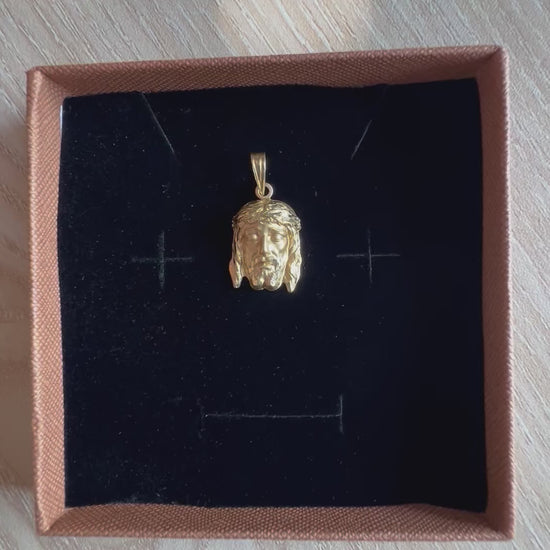 Vidéo de présentation du pendentif tête de Christ en or jaune 18 carats, dévoilant le bijou dans son écrin de velours et mettant en valeur les reflets de la couronne d'épines et la texture mate du visage.