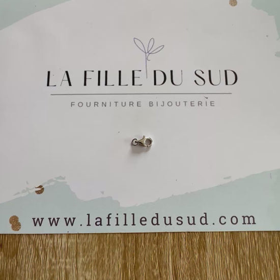 Aperçu en vidéo de la taille d'un fermoir mousqueton or blanc 9mm dans la main.