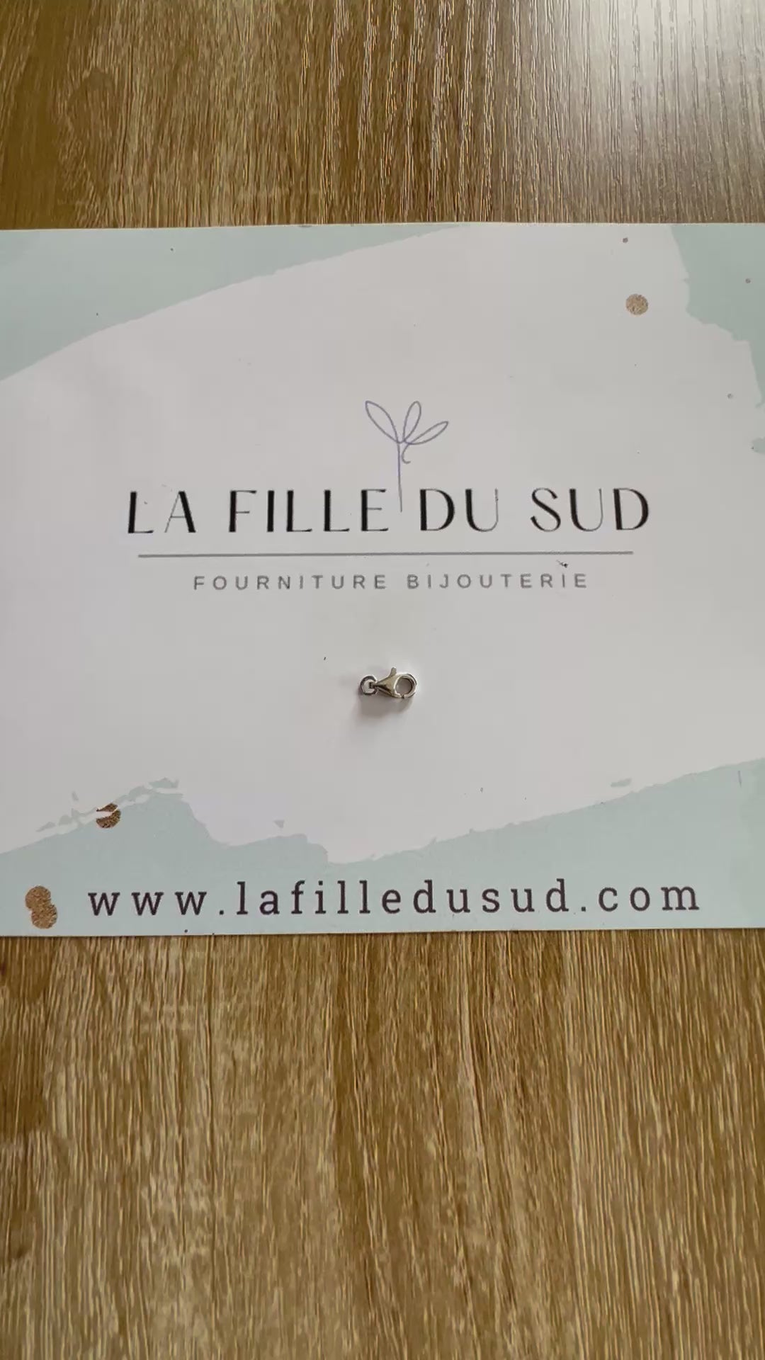 Aperçu en vidéo de la taille d'un fermoir mousqueton or blanc 9mm dans la main.