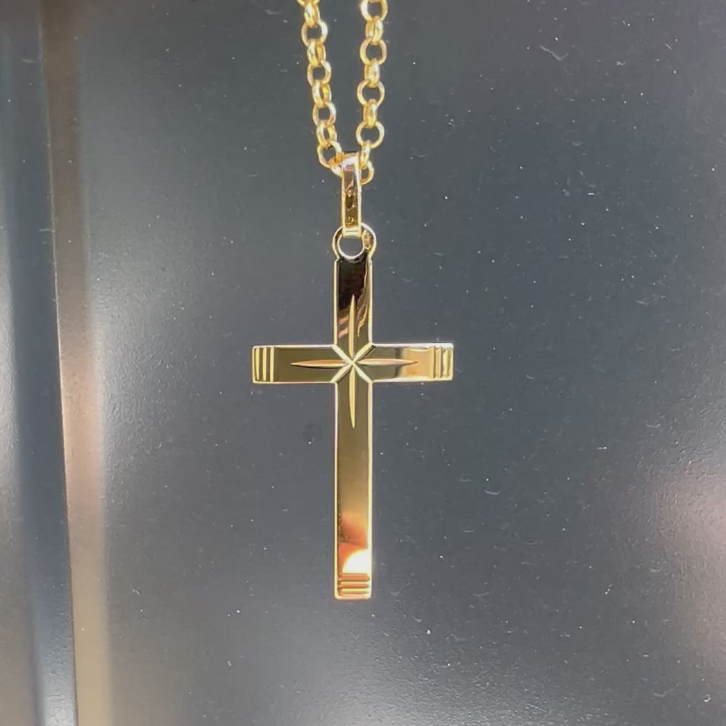 Vidéo d'un pendentif croix en or pour homme 18 carats, or jaune massif avec centre facetté en étoile et extrémités striées, 27 mm de longueur