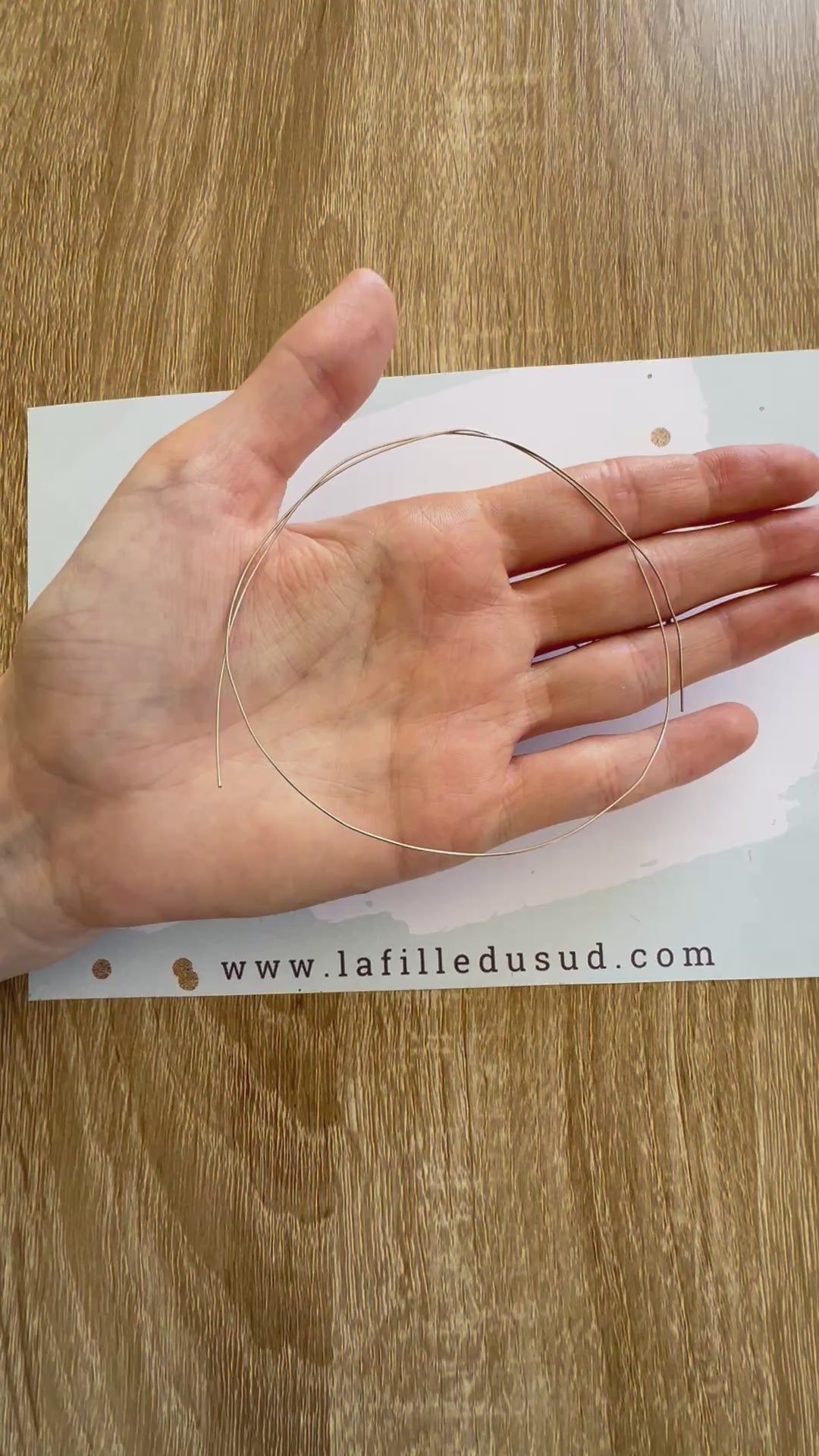 Aperçu en vidéo de la souplesse du fil d'or rond 0,50 mm en or gris 18 carats dans la paume de la main.