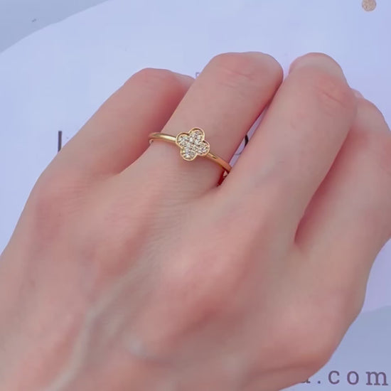 Démonstration de la bague trèfle en or et diamants portée à la main en mouvement sous la lumière.